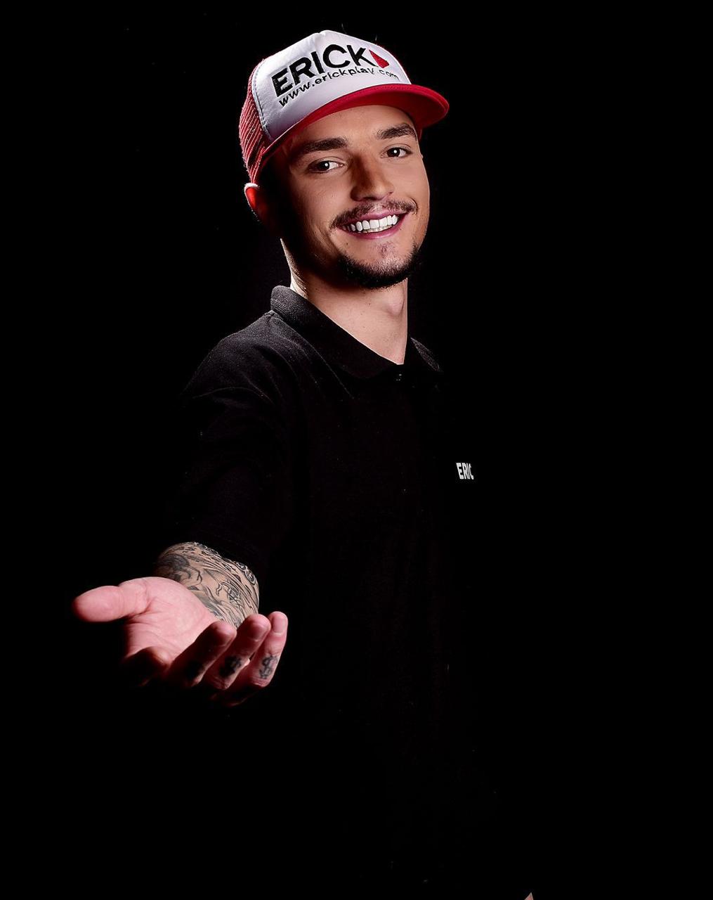 Erick Diaz sorrindo, com a mão estendida em convite